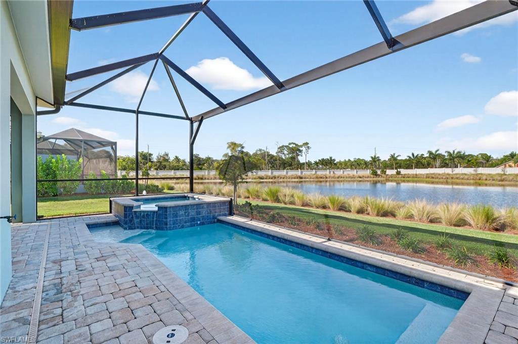 8813 Yucatan Court Naples, FL 34113 - Photo 13 of 43 View of pool featuring a patio area, glass enclosure, a sunroom, a pool with connected hot tub, and a water view