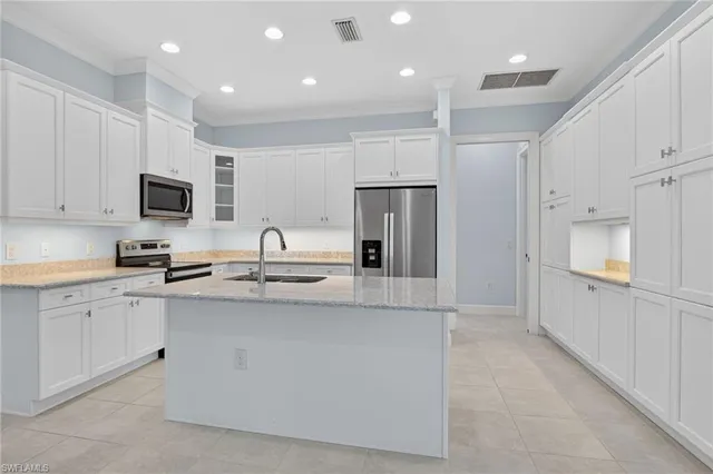 a kitchen with kitchen island a sink stainless steel appliances and cabinets