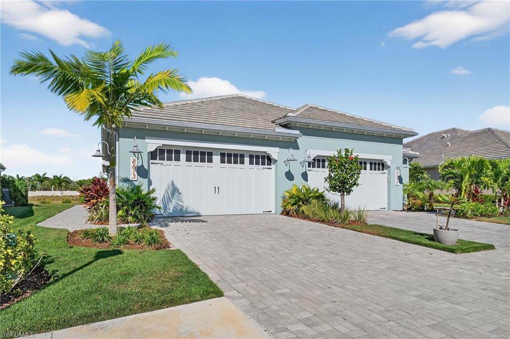 8813 Yucatan Court Naples, FL 34113 - Photo 2 of 43 View of front of property with a tiled roof, stucco siding, decorative driveway, and a garage