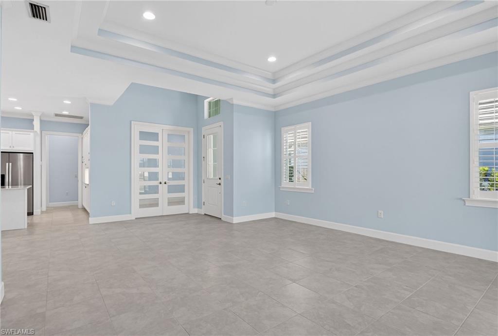 8813 Yucatan Court Naples, FL 34113 - Photo 6 of 43 Unfurnished living room with a raised ceiling, recessed lighting, crown molding, and french doors
