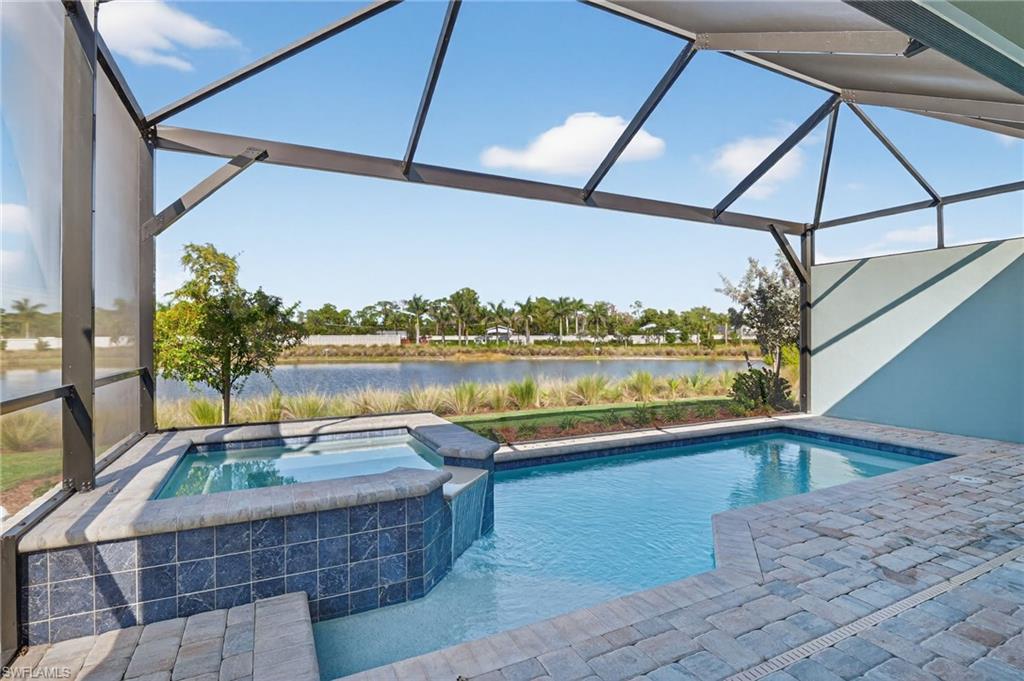8813 Yucatan Court Naples, FL 34113 - Photo 10 of 43 View of swimming pool with screen enclosure, a hot tub, and a water view