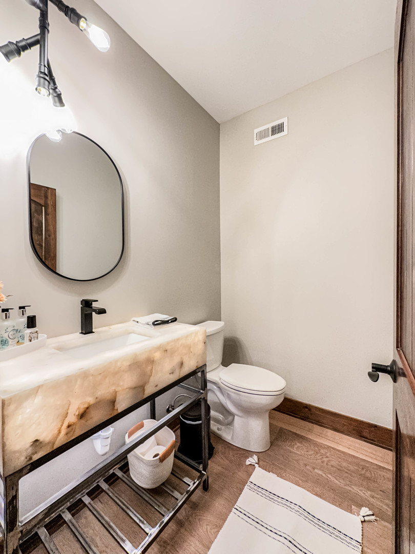 26005 Forrester Drive Plainfield, IL 60585 - Photo 7 of 19 a bathroom with a granite countertop toilet a sink and a mirror