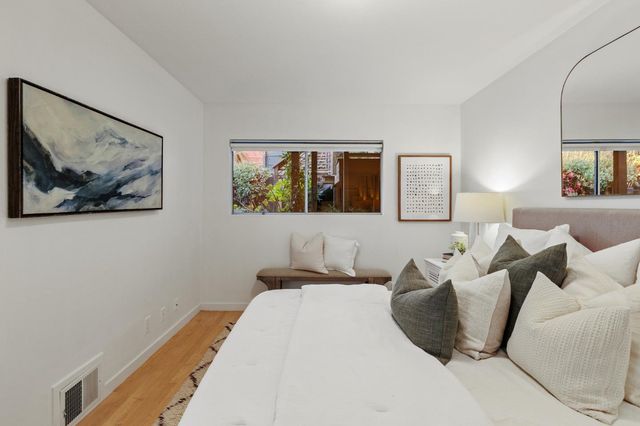 a bedroom with a bed and painting on the wall