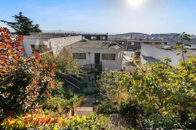 a view of a white house with a yard and plants