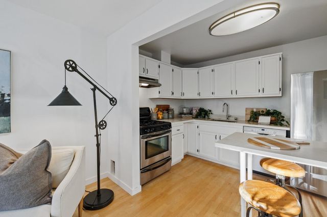 a kitchen with stainless steel appliances granite countertop a stove and white cabinets