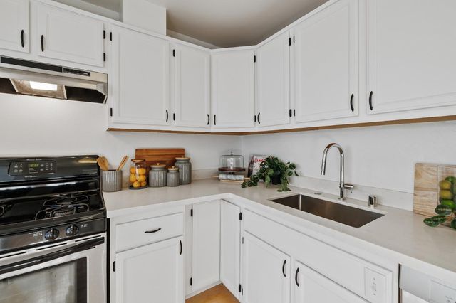 a kitchen with white cabinets and appliances