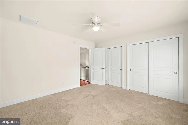 a view of a patio with couches table and chairs under an umbrella with palm trees