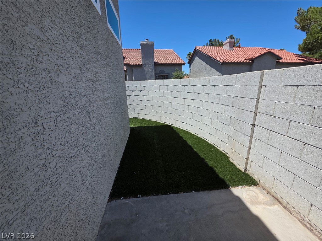 2275 Ramsgate Drive Henderson, NV 89074 - Photo 4 of 84 A private side yard with artificial turf and a sturdy block wall offers low-maintenance outdoor living.