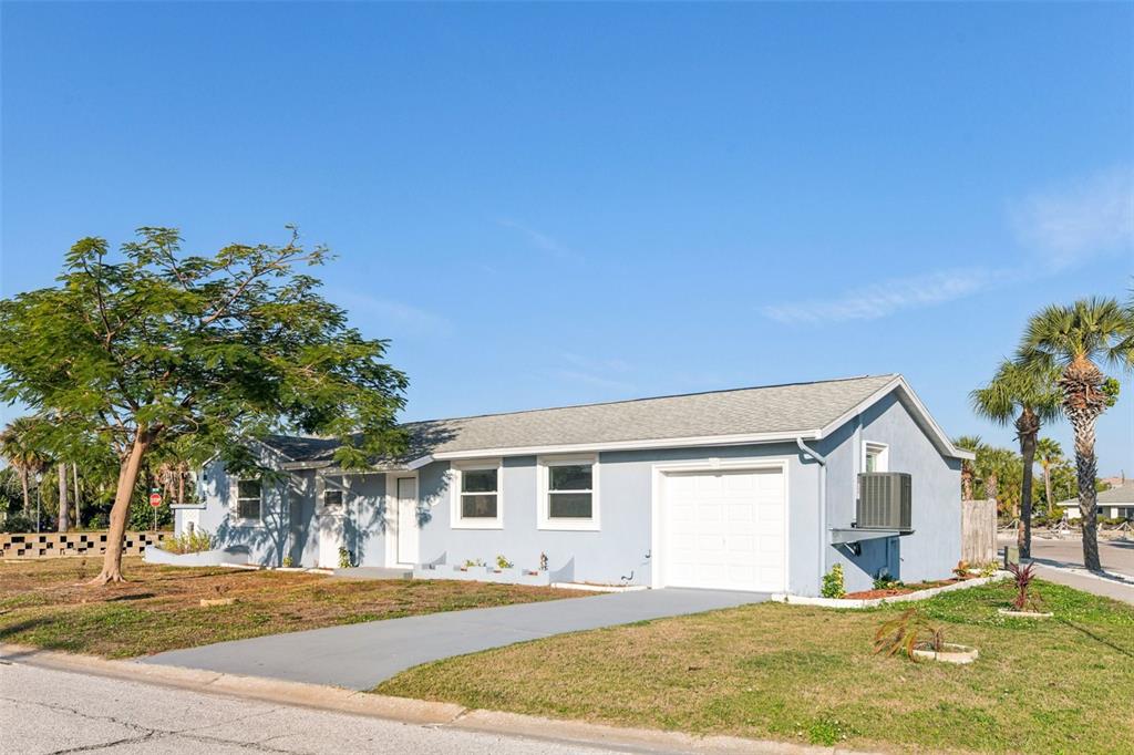 410 Virginia Avenue Madeira Beach, FL 33708 - Photo 2 of 25 a front view of a house with a yard and garage