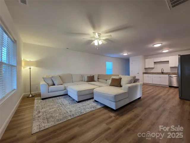 a living room with furniture and kitchen view