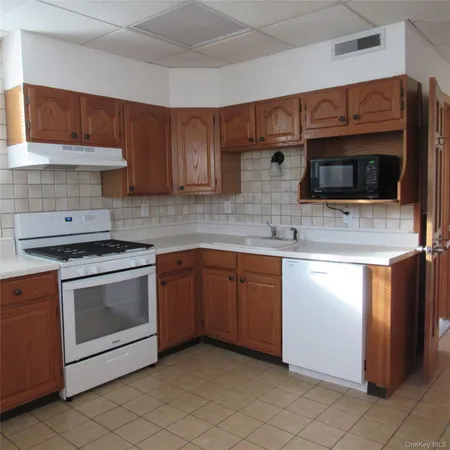 a kitchen with granite countertop a sink and a stove top oven