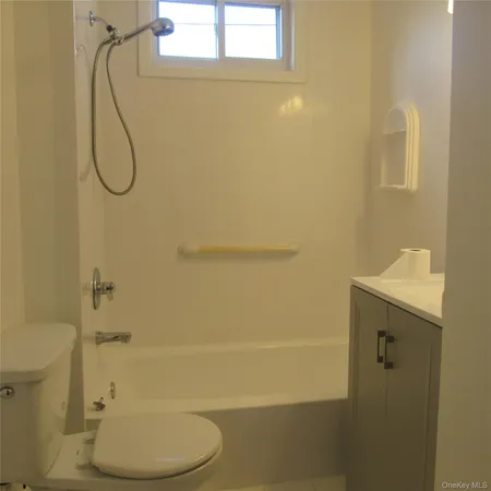 a bathroom with a granite countertop toilet and a sink