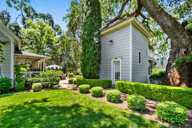 a view of a chair and table in backyard of the house
