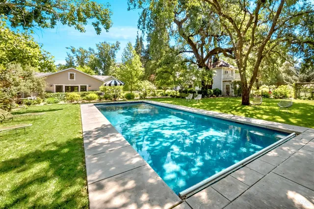 a view of house with yard and outdoor seating