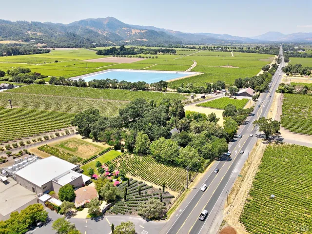 a living room with furniture a chandelier and a wooden floor