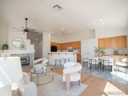 a living room with furniture a rug kitchen view and a chandelier