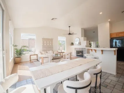 a living room with furniture a fireplace and a chandelier