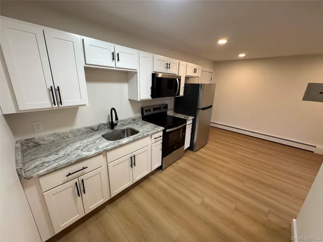 a kitchen with granite countertop a sink and cabinets