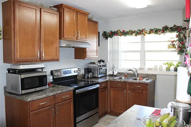 a kitchen with stainless steel appliances granite countertop a sink stove and cabinets
