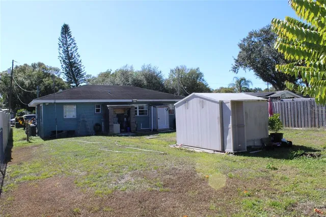a view of a house with a yard and large tree