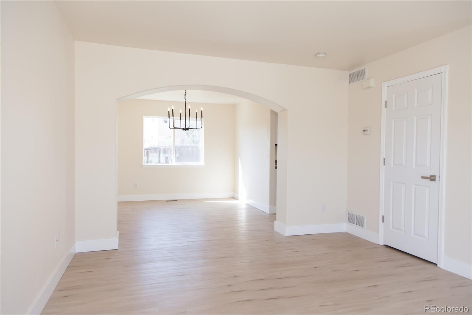 4660 Skylark Road Colorado Springs, CO 80916 - Photo 15 of 33 an empty room with wooden floor and windows