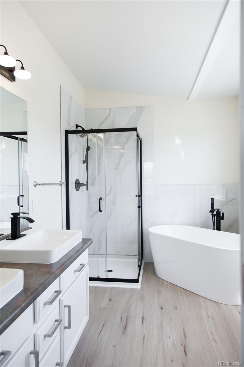 4660 Skylark Road Colorado Springs, CO 80916 - Photo 29 of 33 a bathroom with a granite countertop bathtub sink vanity and mirror