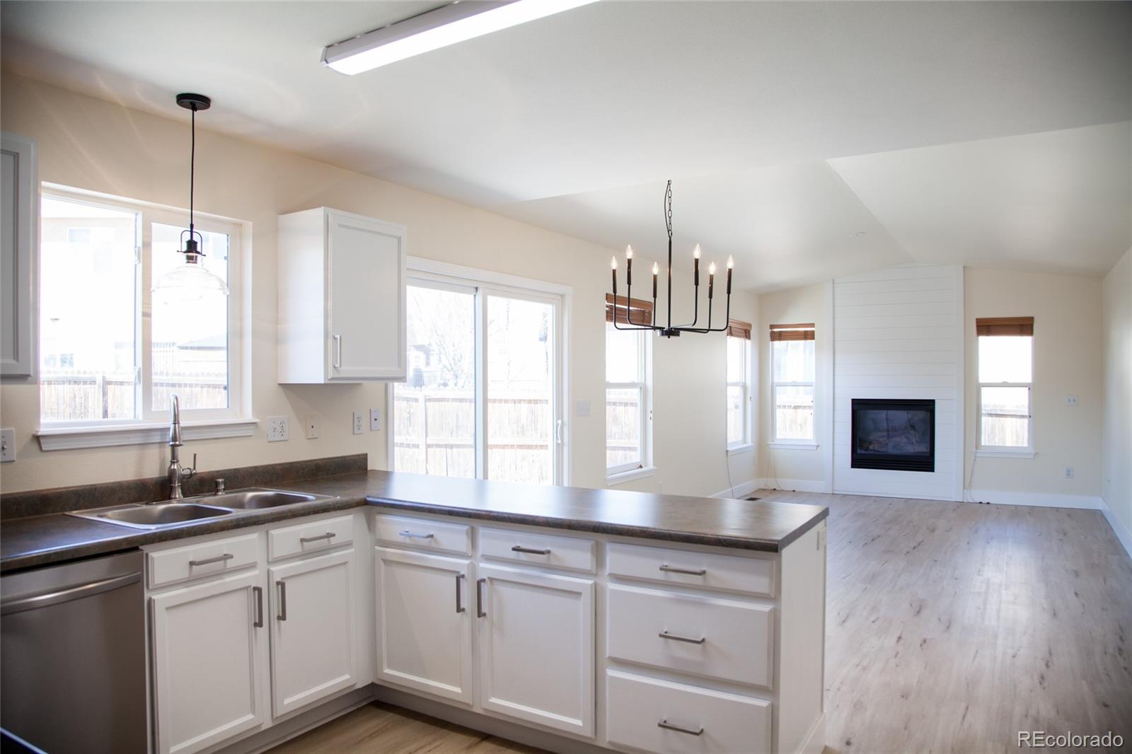 4660 Skylark Road Colorado Springs, CO 80916 - Photo 3 of 33 a kitchen with granite countertop white cabinets and a wooden floor