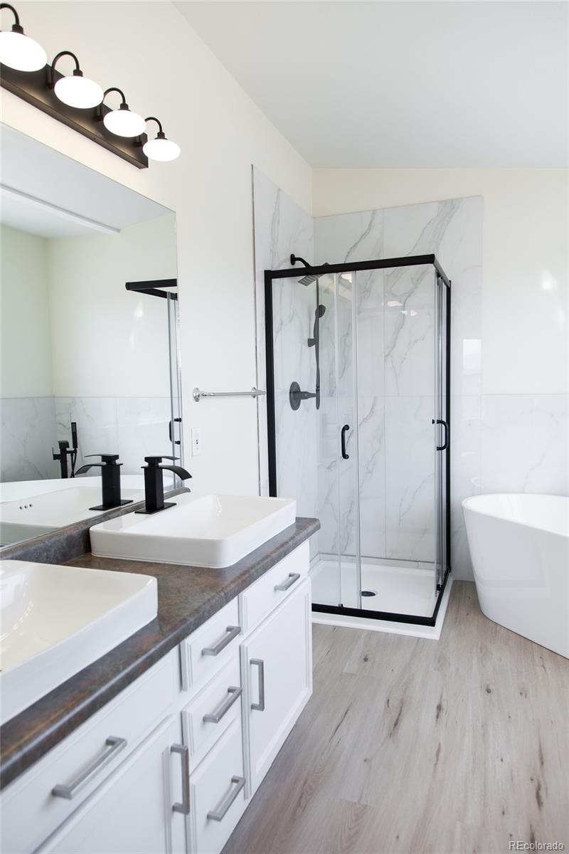 4660 Skylark Road Colorado Springs, CO 80916 - Photo 31 of 33 a spacious bathroom with a double vanity sink and a mirror