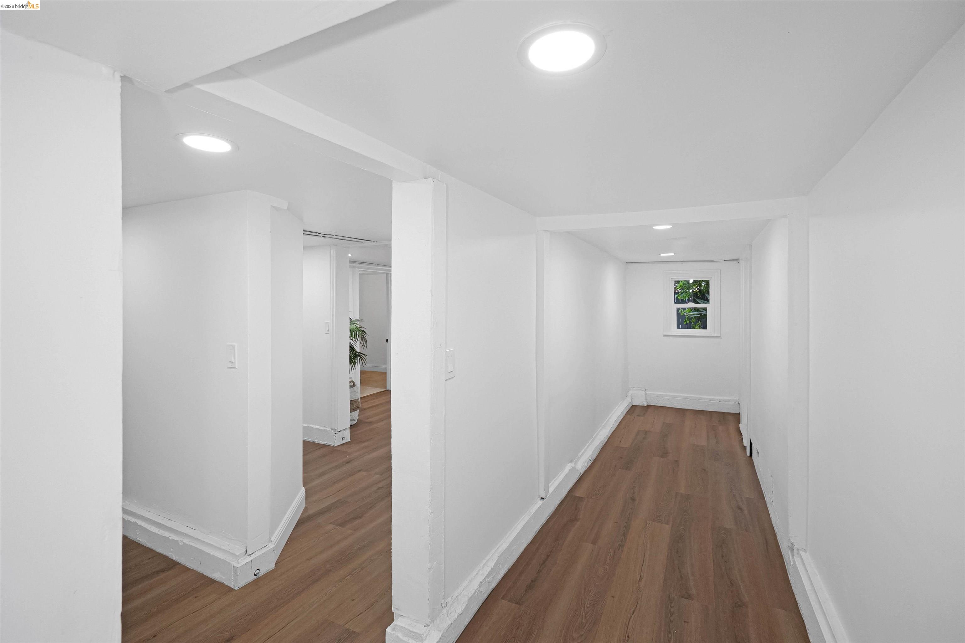 1812 Woolsey Street Berkeley, CA 94703 - Photo 42 of 48 Hallway featuring wood-finish flooring, recessed lighting, white walls, and a window with exterior visibility