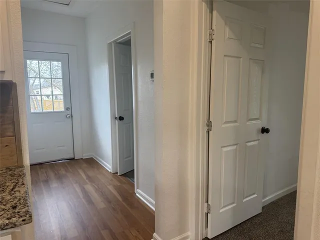 a kitchen with granite countertop wooden floors appliances and sink