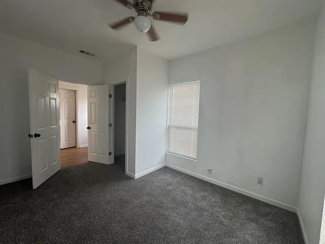 an empty room with a empty space and a ceiling fan