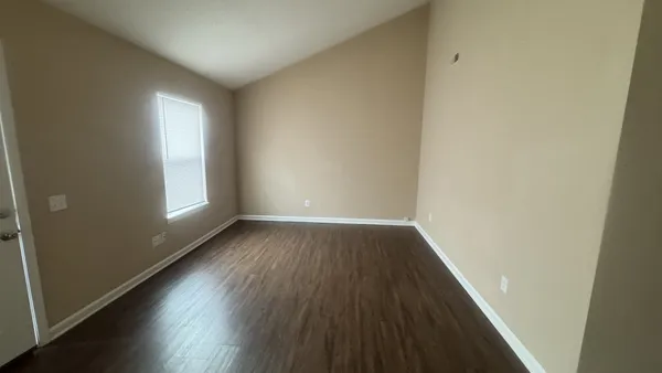 a view of an empty room and wooden floor