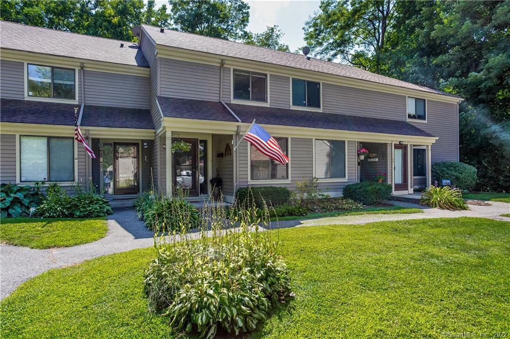 a front view of a house with yard and green space