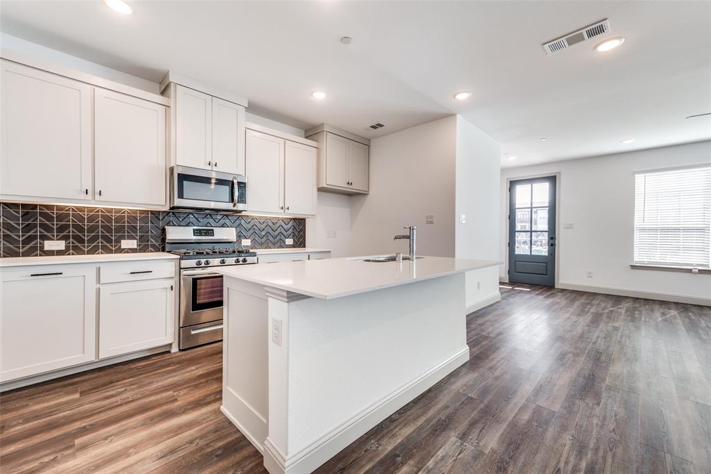 15866 Yellow Elder Road Frisco, TX 75035 - Photo 7 of 25 a kitchen with stainless steel appliances white cabinets a sink and a stove