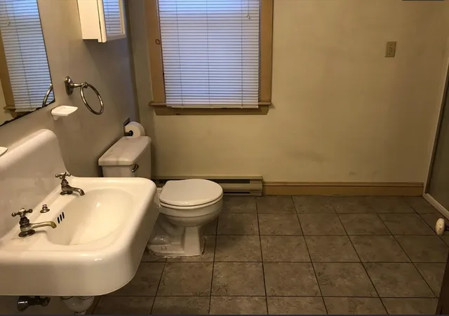 a bathroom with a sink a toilet and mirror