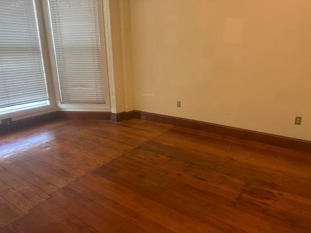 a view of a room with wooden floor and white walls