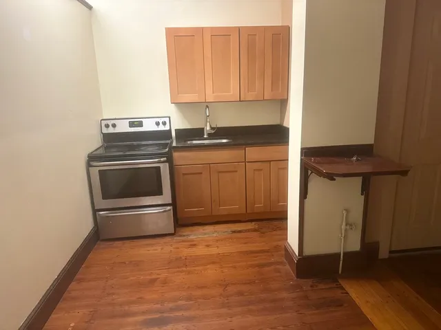 a kitchen with granite countertop a stove and a refrigerator