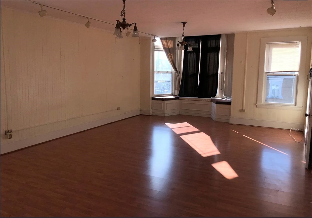 3 Elm Street, Unit 2 Framingham, MA 01701 - Photo 3 of 29 an empty room with wooden floor and windows