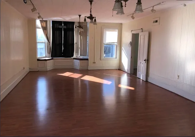 a view of a hallway with wooden floor and a window