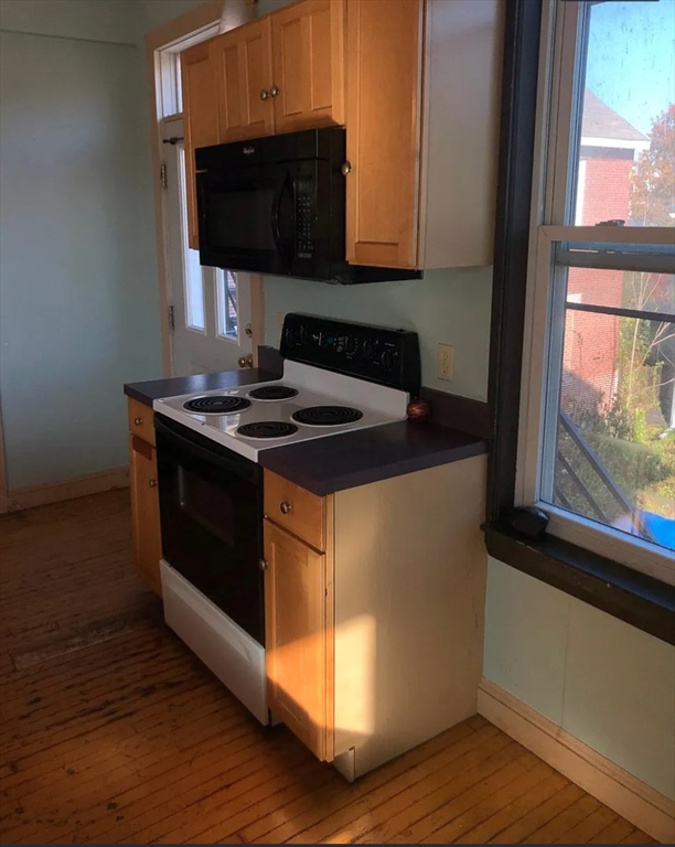 3 Elm Street, Unit 2 Framingham, MA 01701 - Photo 8 of 29 a kitchen with stainless steel appliances granite countertop a stove a sink and a microwave