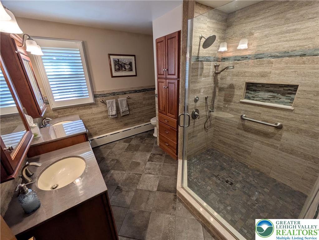 3285 Cherryville Road Northampton, PA 18067 - Photo 22 of 51 Stone tile finishes and a spacious walk-in shower define this well-appointed bathroom.