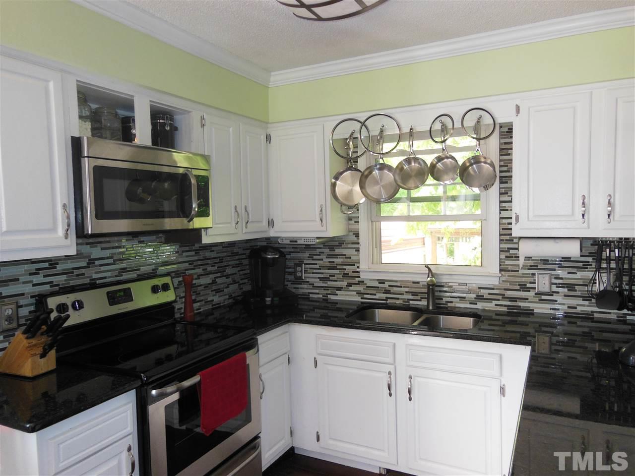 1125 Marlborough Road Raleigh, NC 27610 - Photo 2 of 23 a kitchen with stainless steel appliances a stove a microwave and cabinets