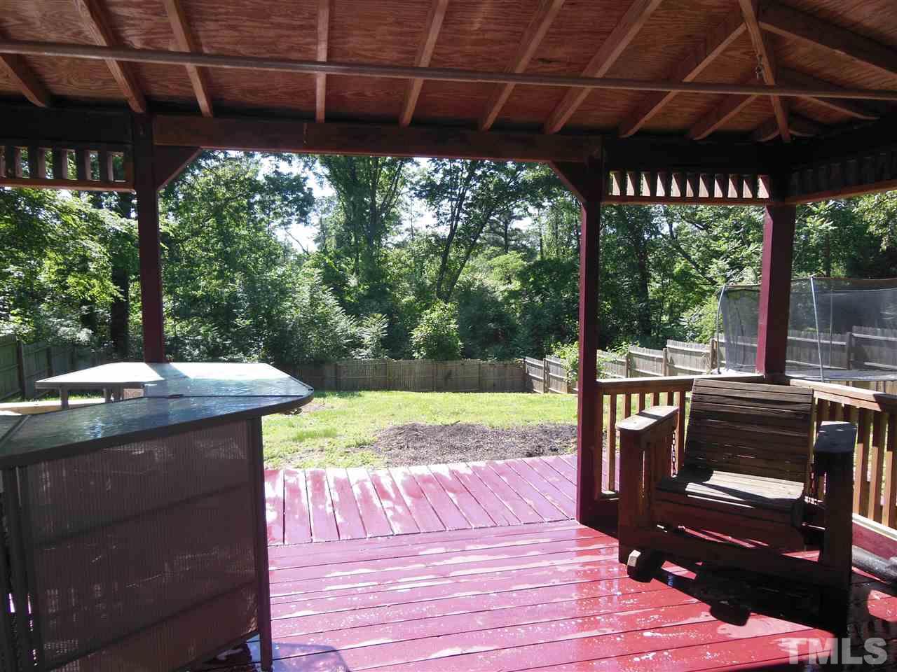1125 Marlborough Road Raleigh, NC 27610 - Photo 22 of 23 a view of a patio with table and chairs under an umbrella with a small yard