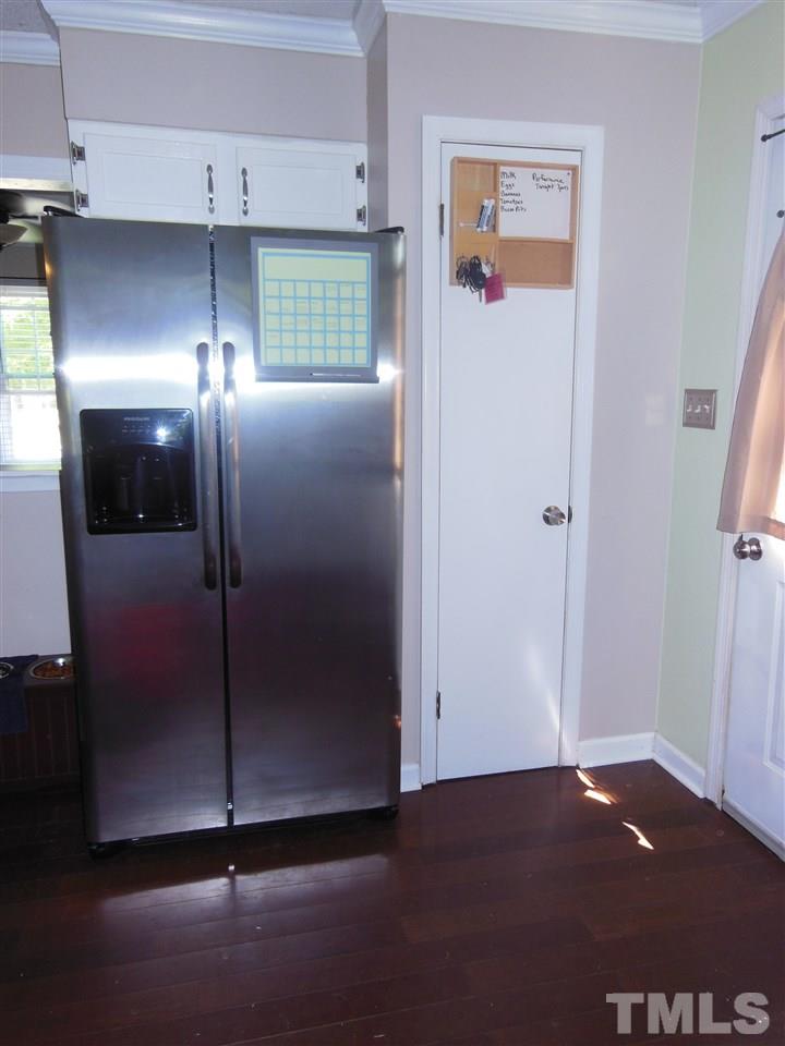 1125 Marlborough Road Raleigh, NC 27610 - Photo 7 of 23 a view of a refrigerator in kitchen and an empty room with windows