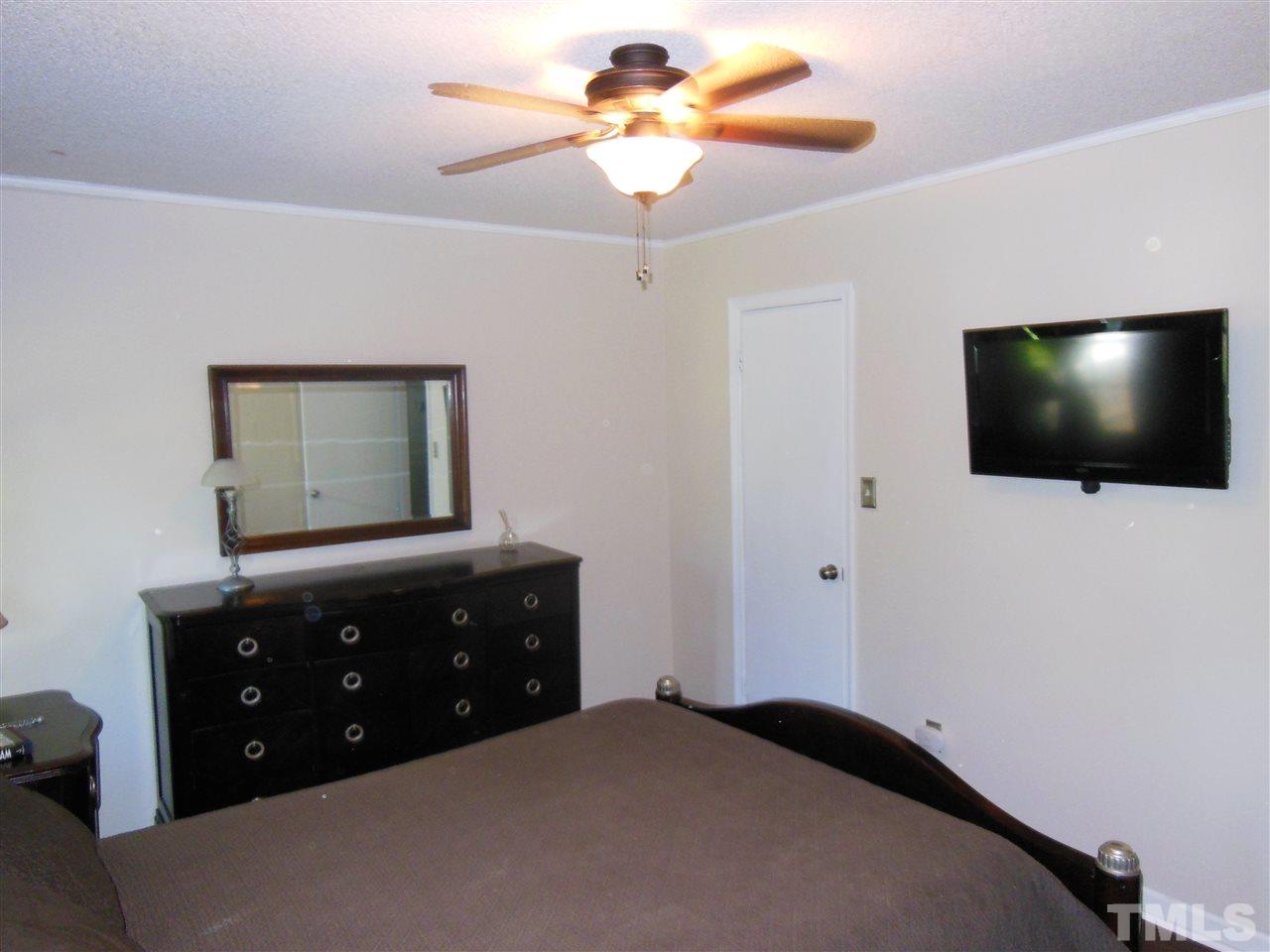 1125 Marlborough Road Raleigh, NC 27610 - Photo 10 of 23 a bedroom with a bed and a flat tv screen on dresser