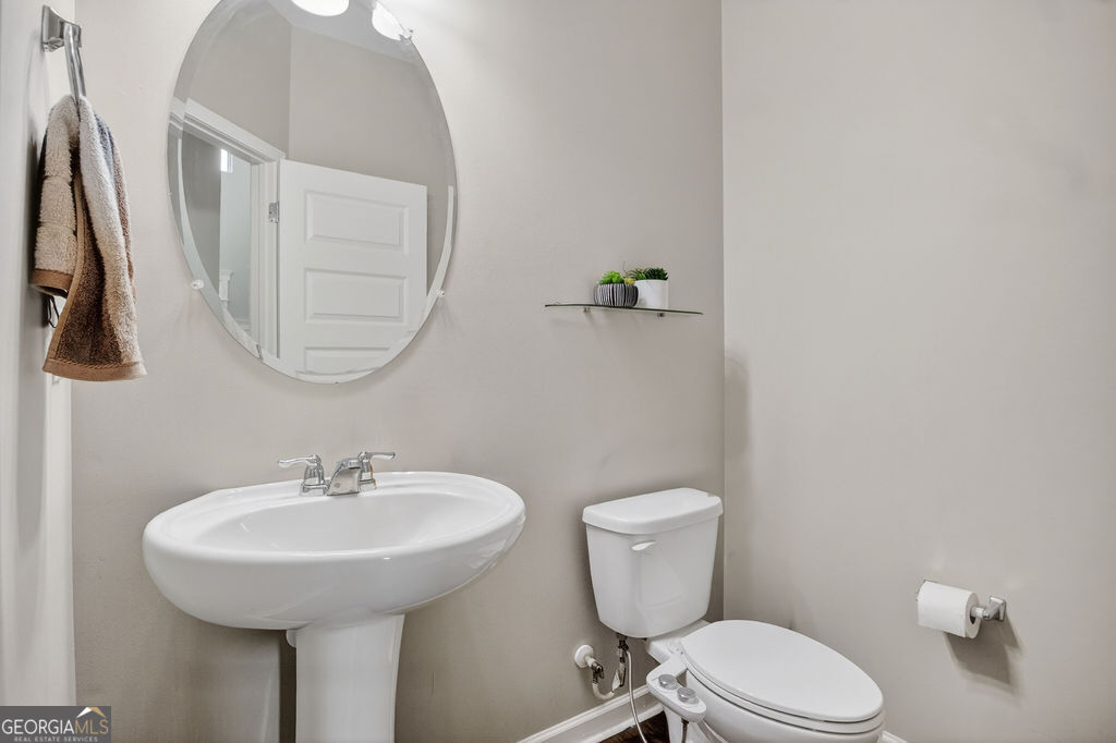 3495 Zaks Way Bethlehem, GA 30620 - Photo 18 of 40 a bathroom with a toilet a sink and a mirror