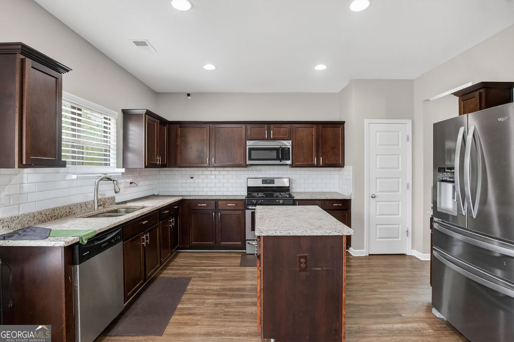 3495 Zaks Way Bethlehem, GA 30620 - Photo 10 of 40 a kitchen with stainless steel appliances granite countertop a refrigerator a sink a stove a microwave and wooden cabinets