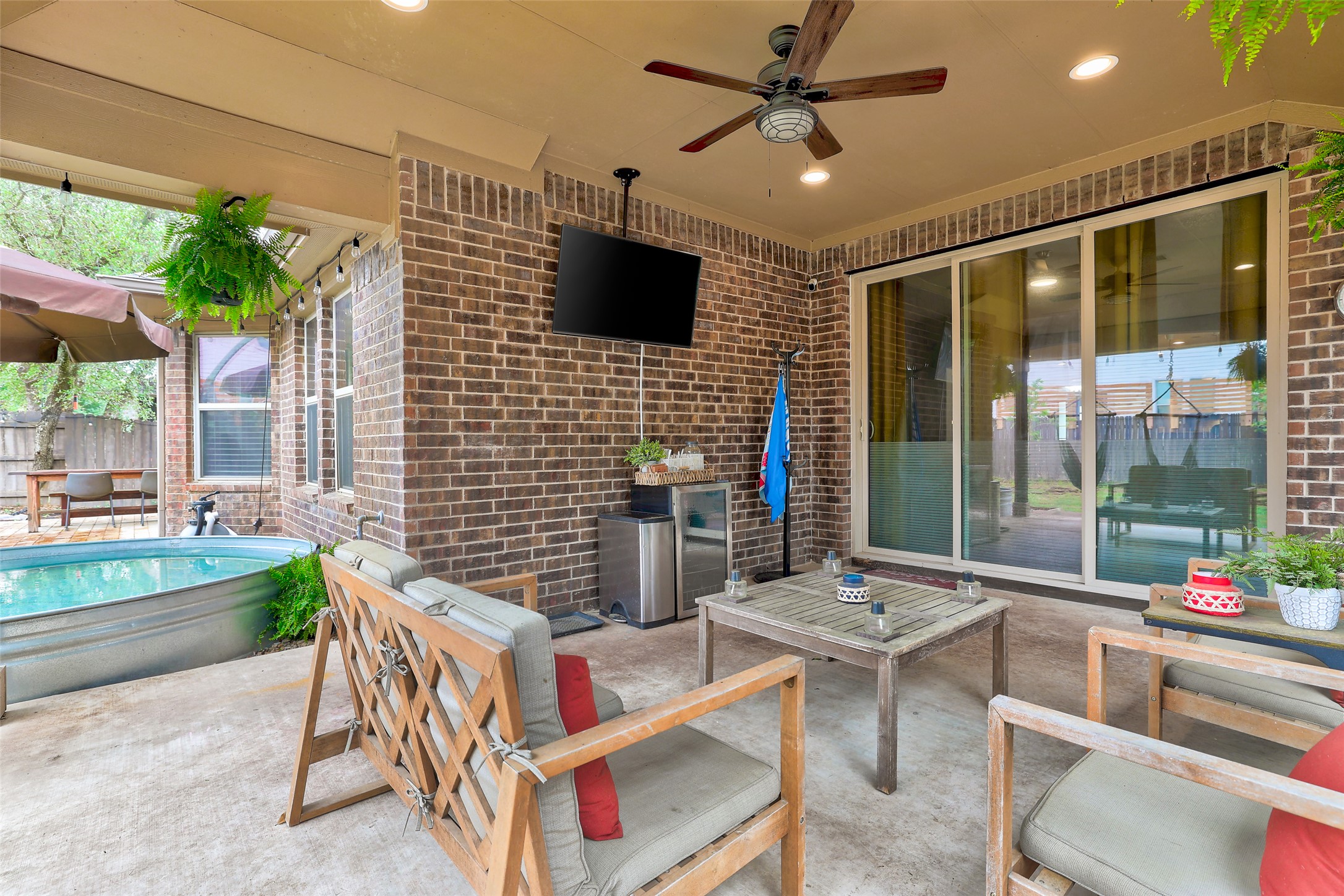 117 Rock Dock Road Georgetown, TX 78633 - Photo 37 of 39 The property features a covered patio with brick walls and a ceiling fan, offering a comfortable outdoor living space