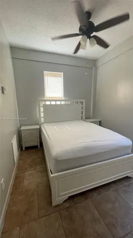a bedroom with a bed and a ceiling fan
