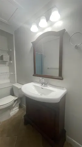 a bathroom with a sink toilet and mirror